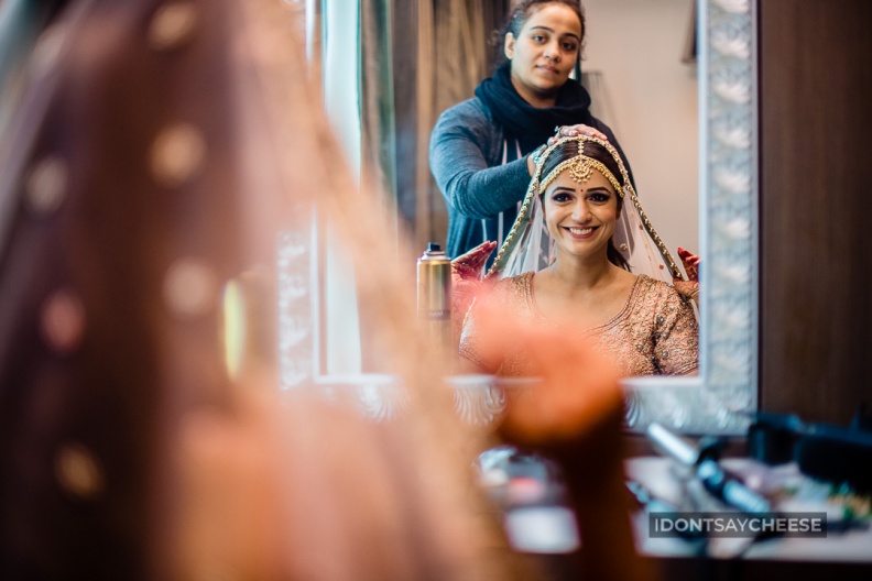 Bridal Candid Photography - Getting ready in pink lehenga on wedding